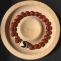 Pray Tai Sui God 2025 Protection Auspicious Light Guardian Bracelet – South Red Agate Tibetan Tiger Eye Dzi Bead Gold Dzambhala Bead on a wood plate